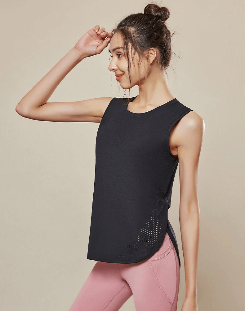 Woman wearing a black sleeveless mesh yoga top, showing its loose fit and breathable fabric, ideal for comfortable workouts.